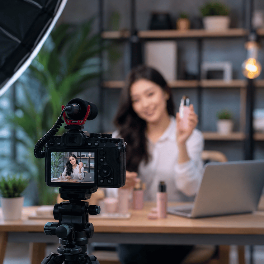 Realistic advertisement video production setup showing a content creator presenting a product in front of a professional camera in a modern studio.