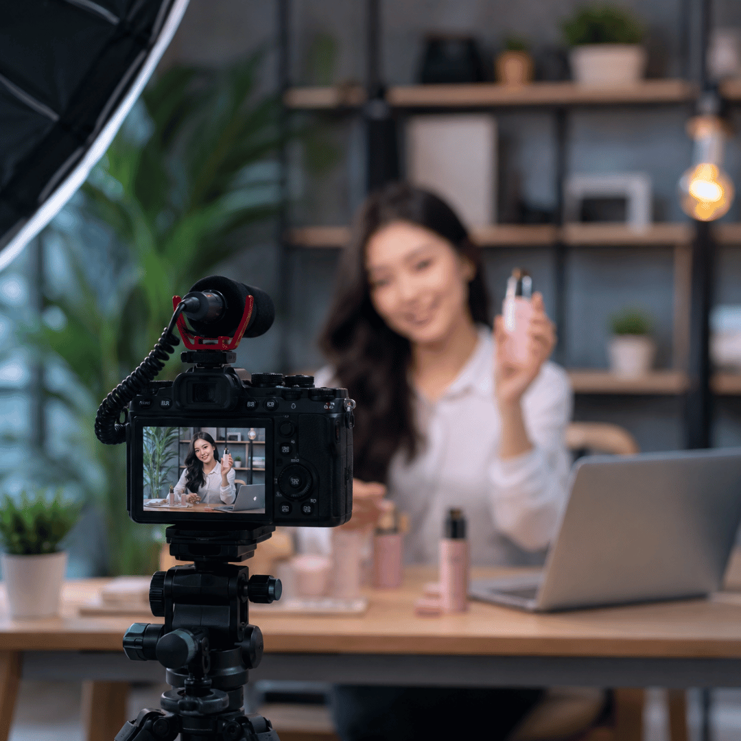 Realistic advertisement video production setup showing a content creator presenting a product in front of a professional camera in a modern studio.