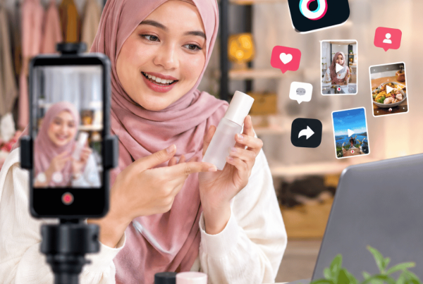Realistic TikTok video marketing setup featuring a creator filming UGC content with a smartphone, supported by social media engagement visuals and digital content tools.